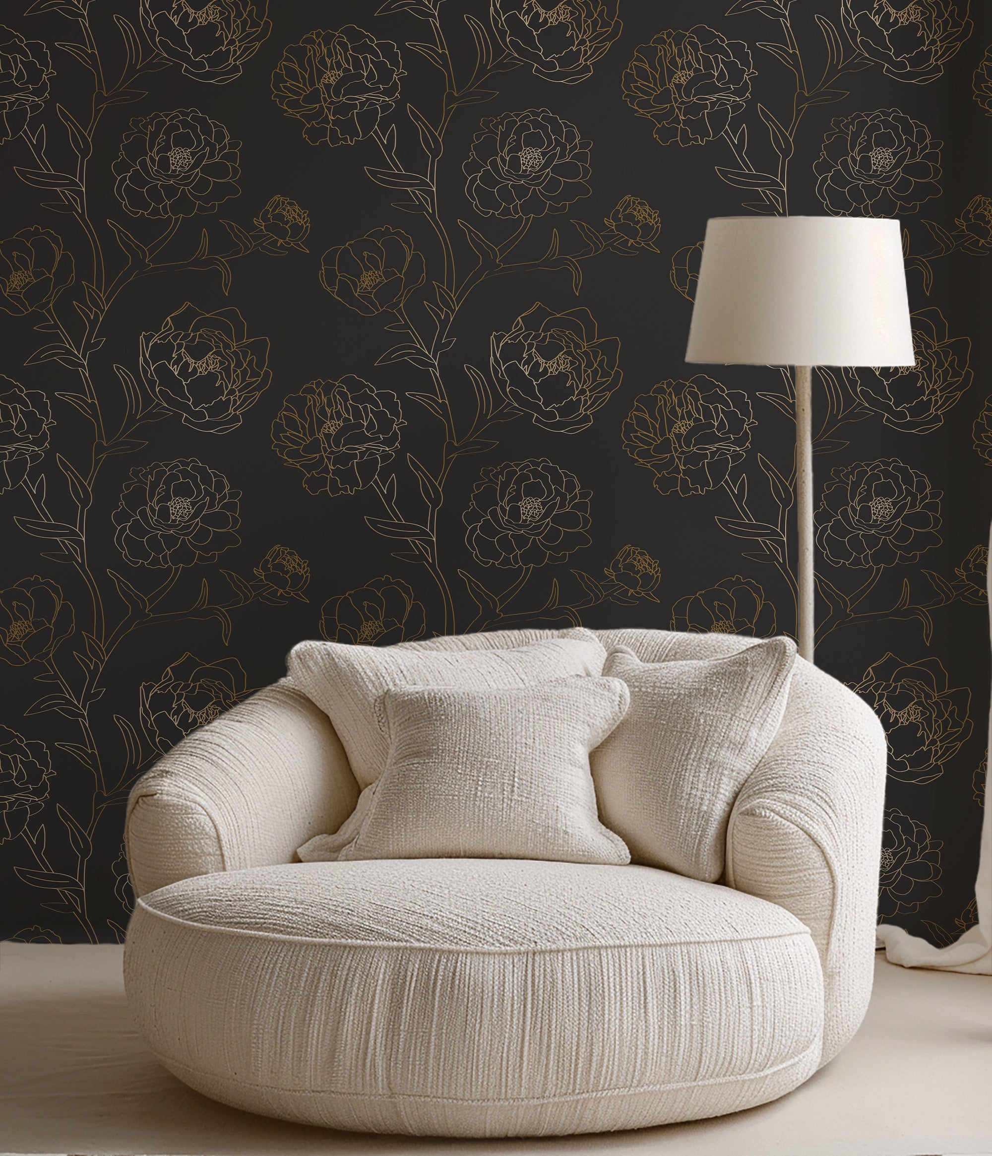 Beige armchair with decorative pillows against a dark floral wallpaper wall.